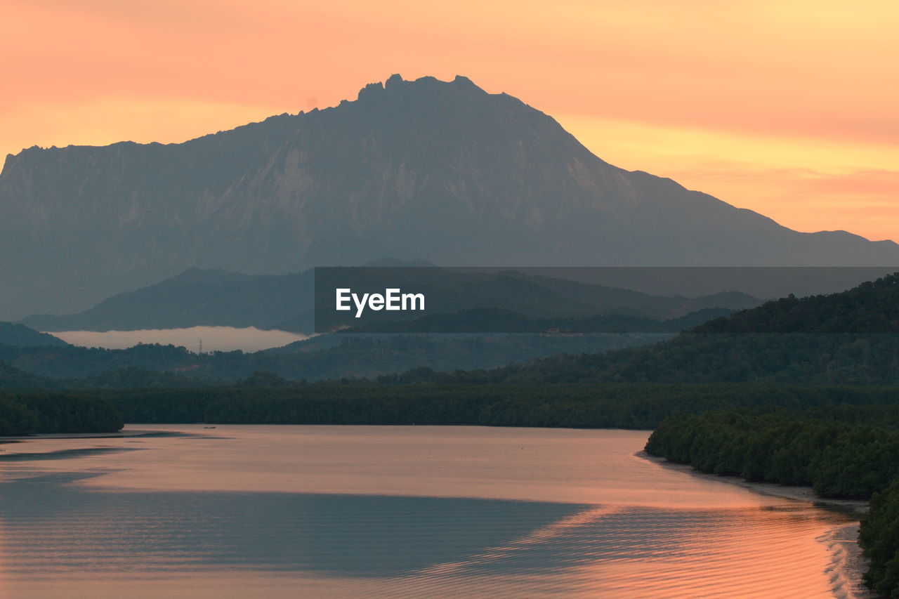 Scenic view of mountains against sky at sunset