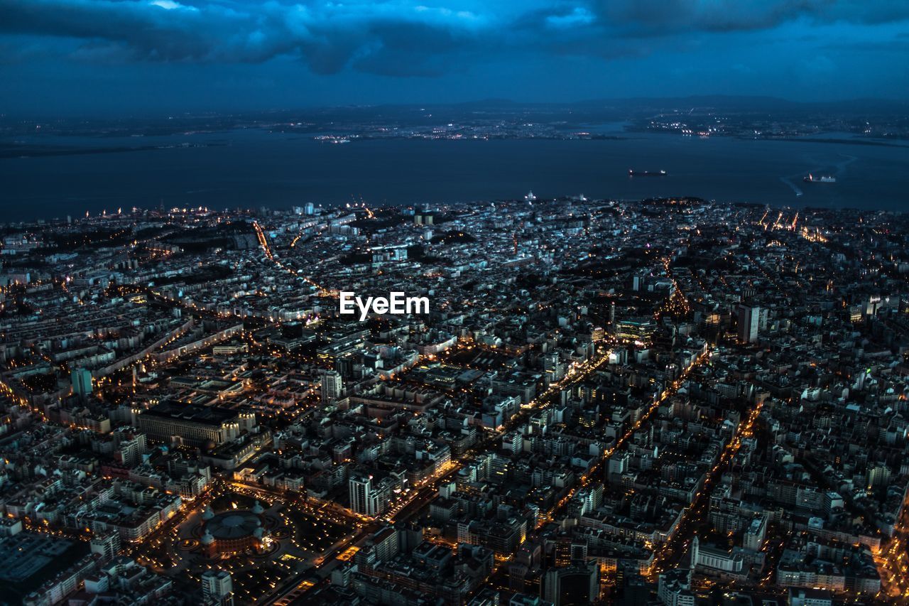 Aerial view of illuminated cityscape of lisbon portugal against sky