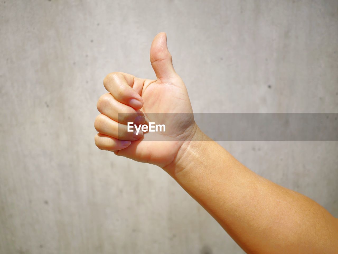 Close-up of person hand gesturing against wall