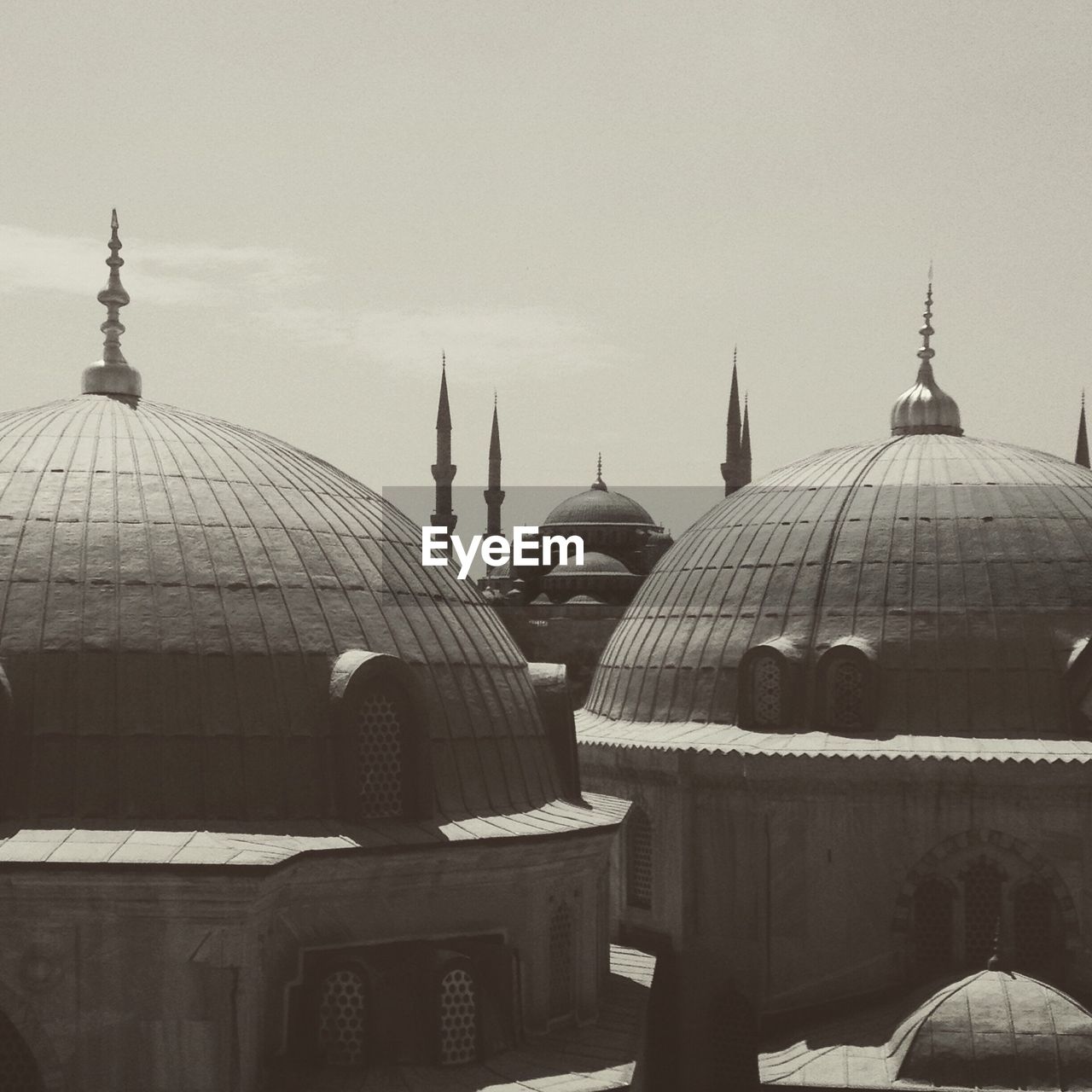 Mosque in city against sky