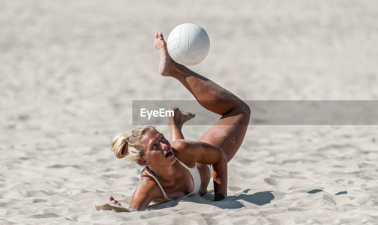 Full length of shirtless young woman on beach