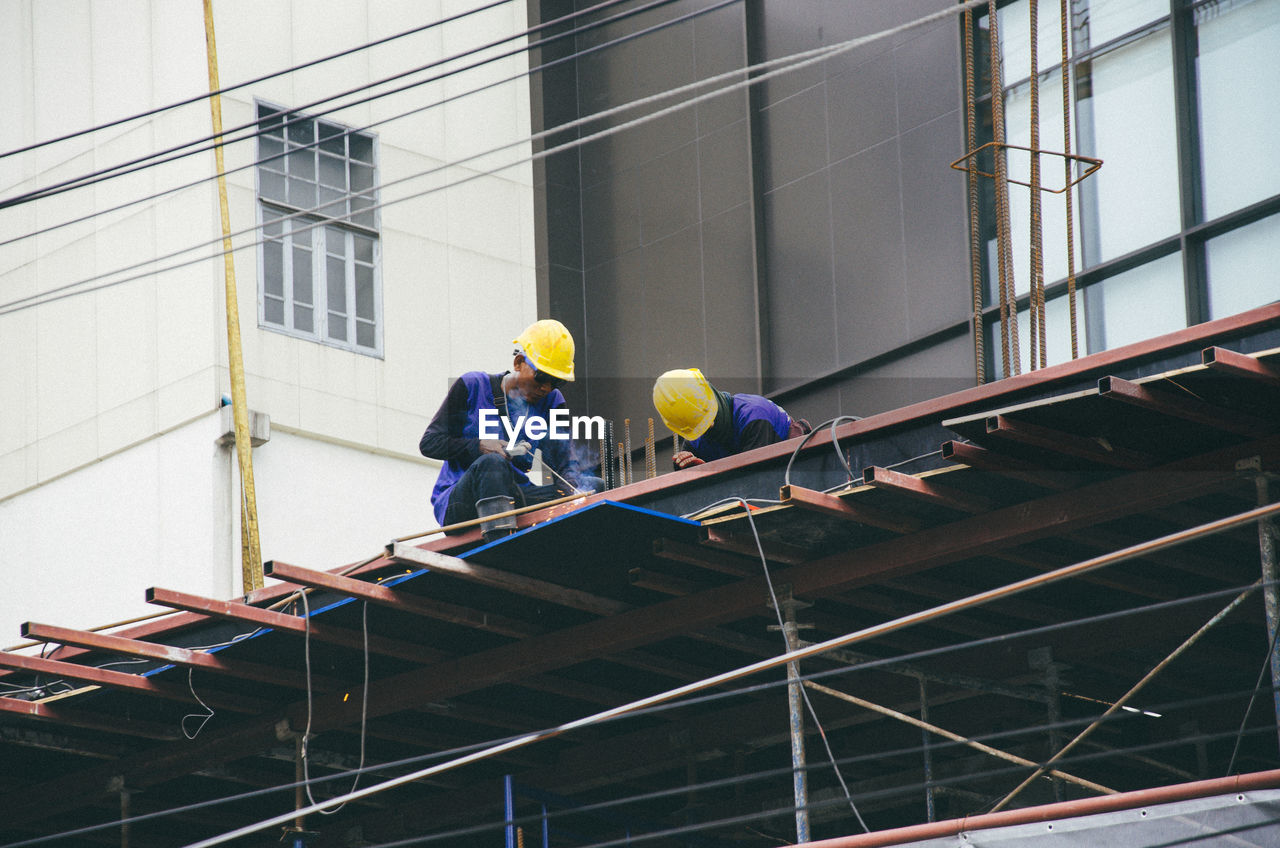 LOW ANGLE VIEW OF MEN WORKING IN BUILDING