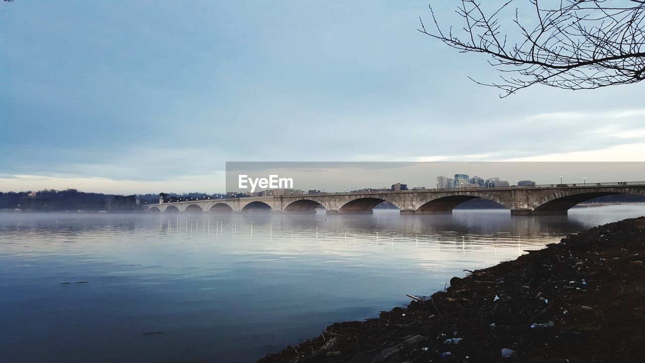 Arch bridge over river against sky