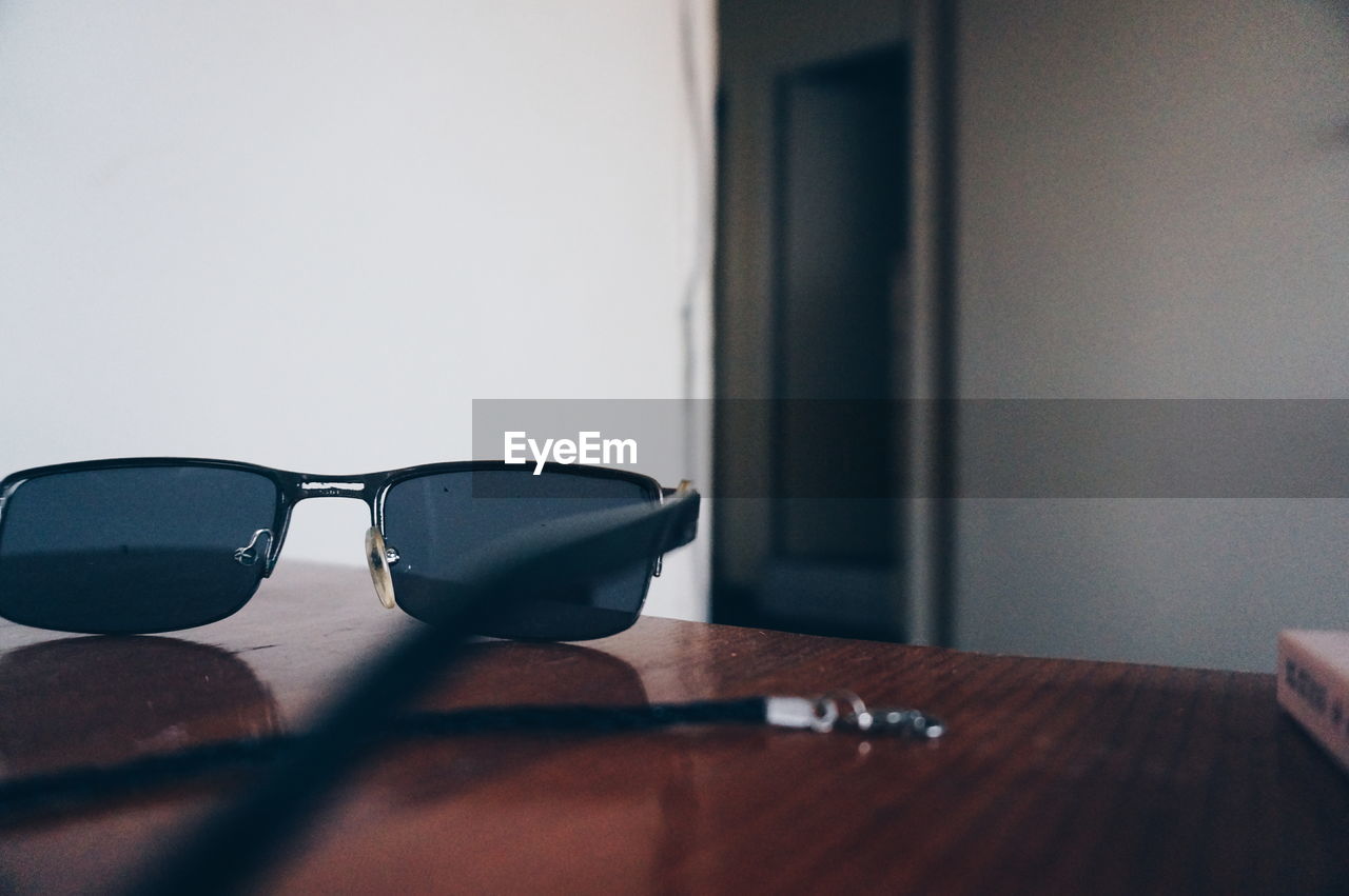 CLOSE-UP OF SUNGLASSES AND TABLE ON MIRROR