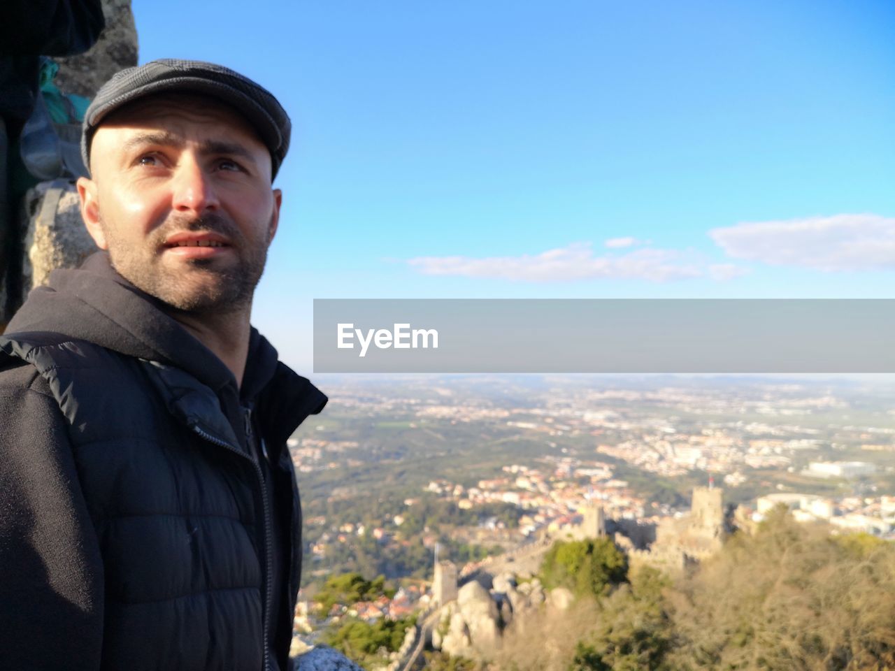 Man looking away while standing against sky