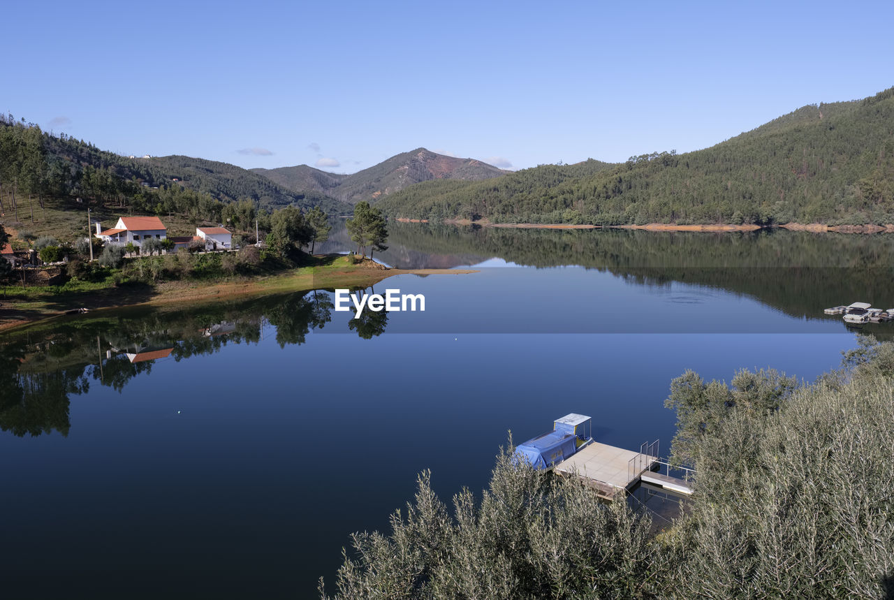 SCENIC VIEW OF LAKE BY TREES AGAINST SKY