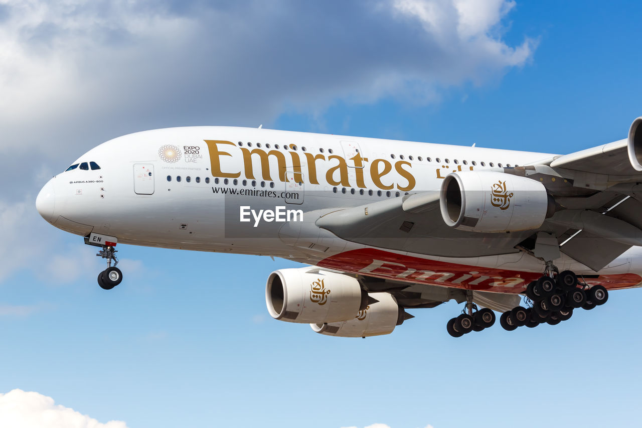 LOW ANGLE VIEW OF AIRPLANE FLYING AGAINST BLUE SKY