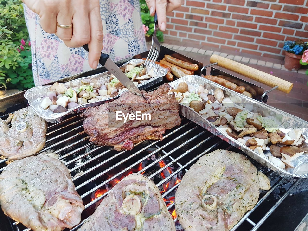 Midsection of man preparing food on barbecue grill