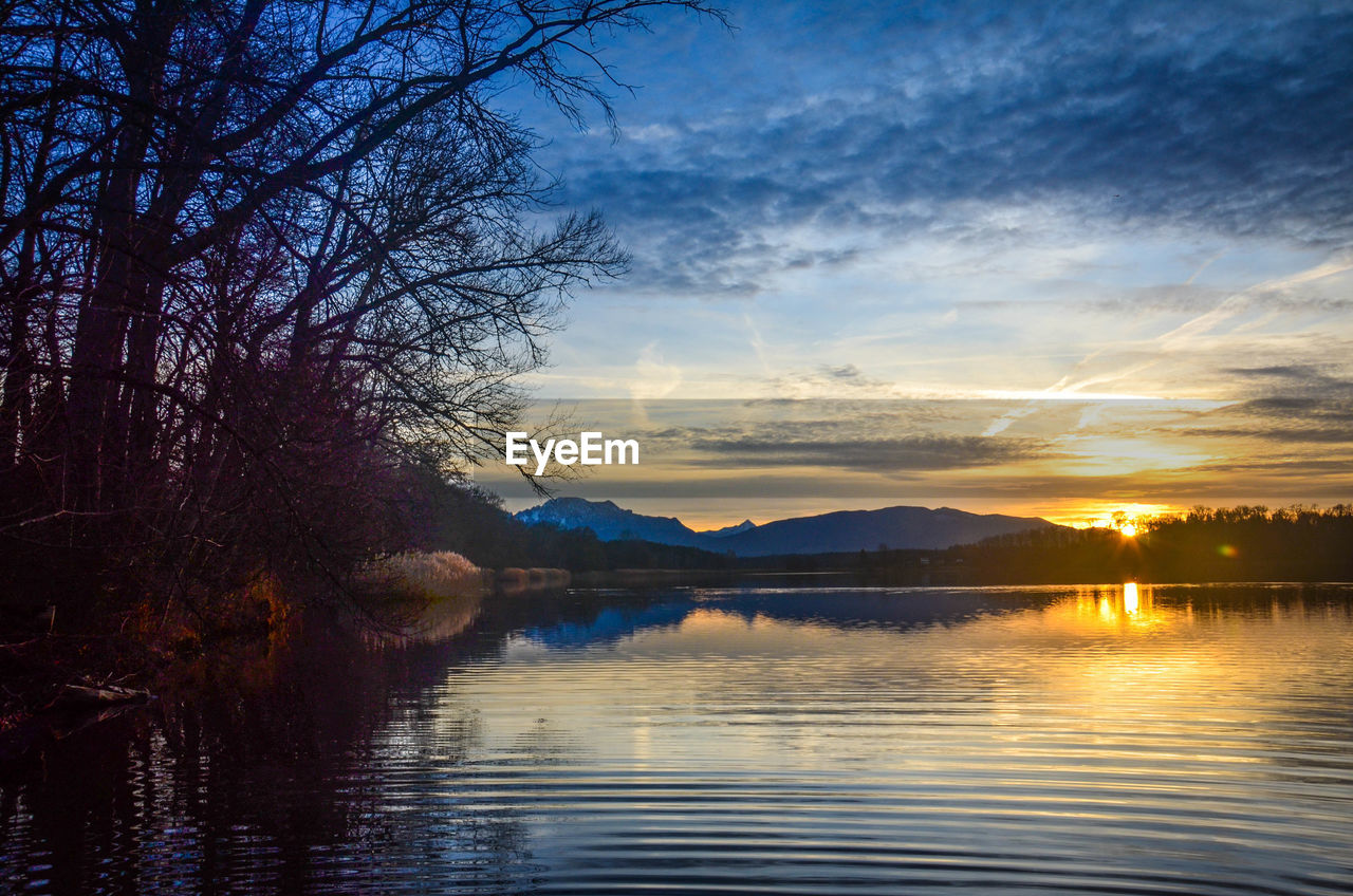 Scenic view of river against sky at sunset