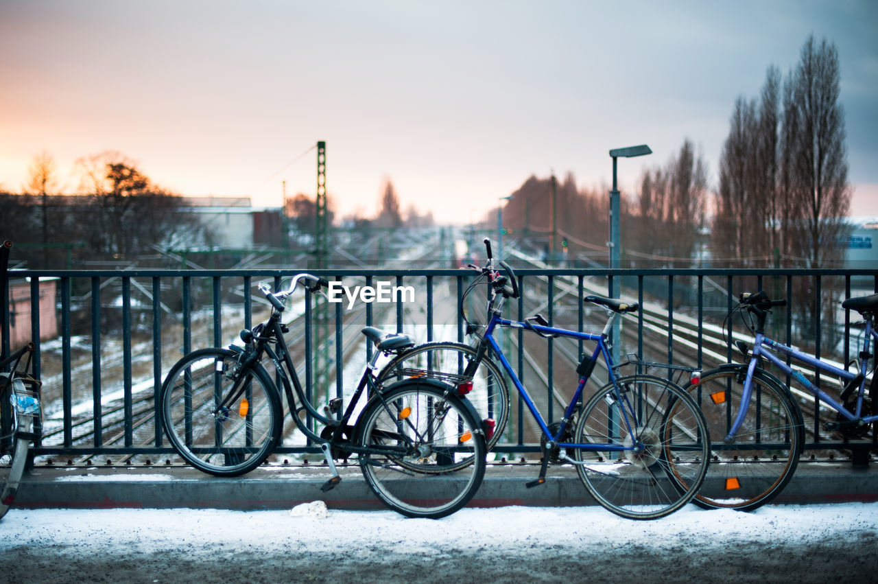 View of bicycles on bridge during winter against sly