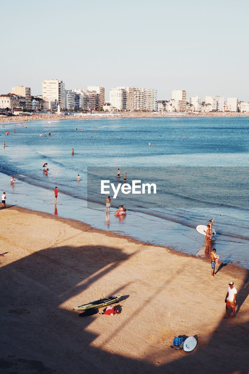 People on beach against clear sky