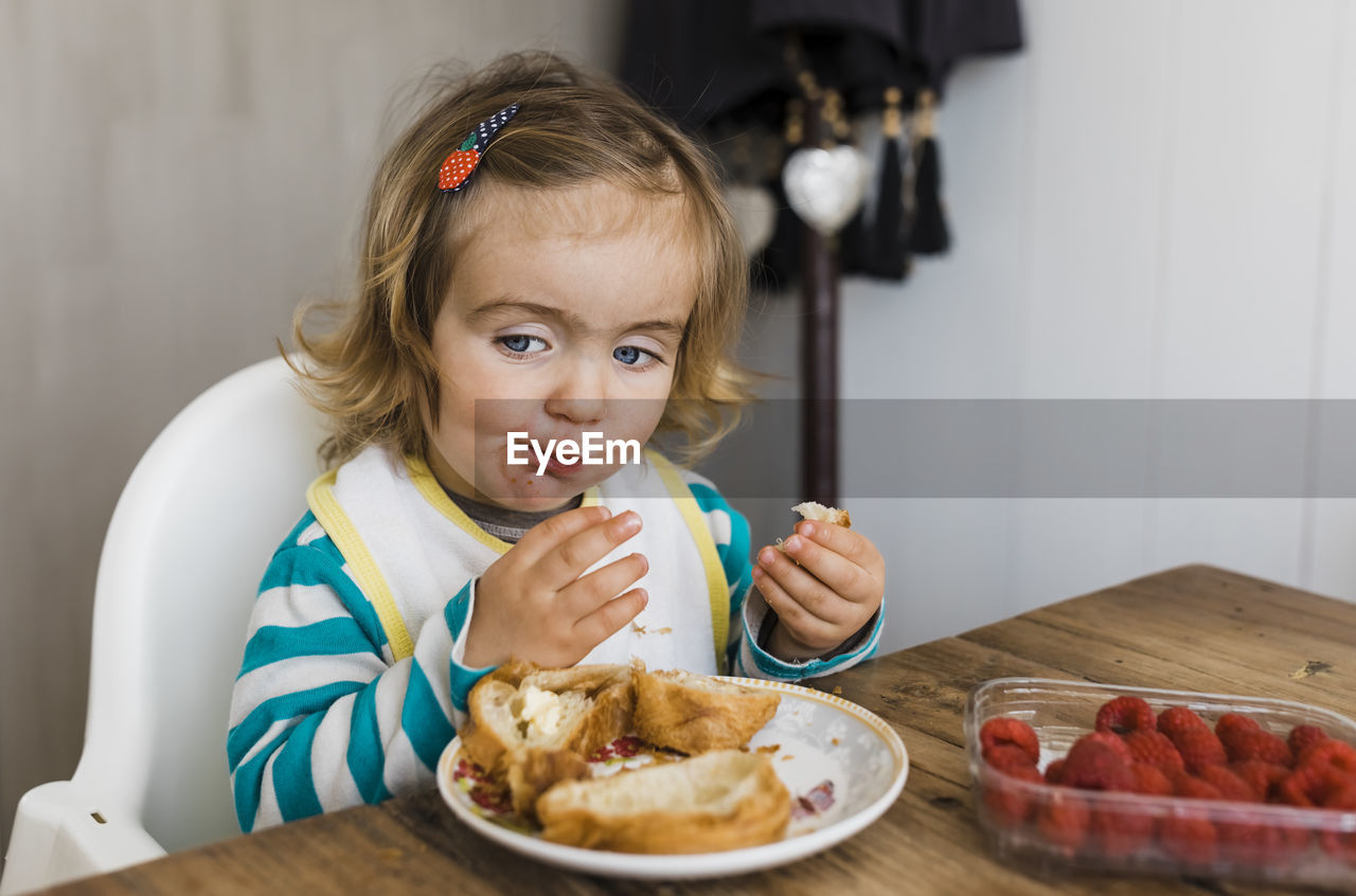 Girl eating breakfast at table