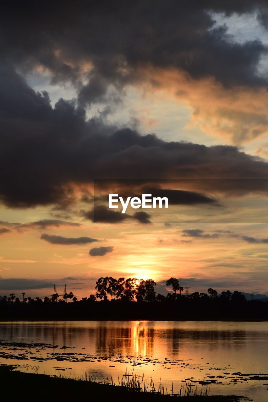 SCENIC VIEW OF LAKE AGAINST DRAMATIC SKY