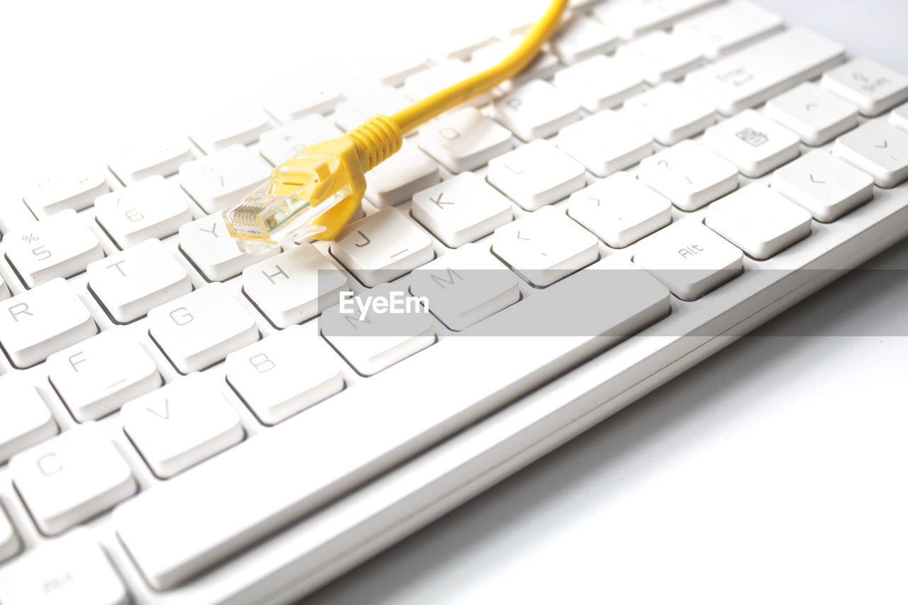 High angle view of cable on keyboard against white background