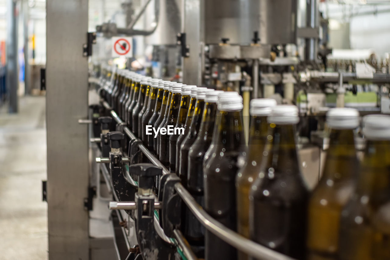 Brown glass bottles of drinking water move on the conveyor belt in the production hall