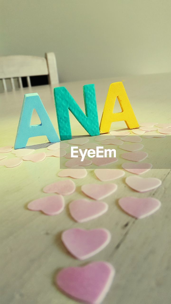 Text and heart shaped cardboard on table