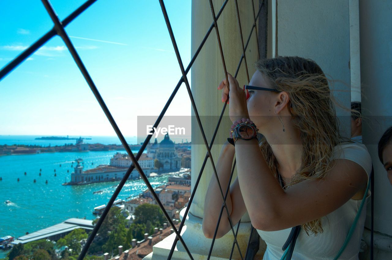 Woman looking through window with santa maria della salute in background