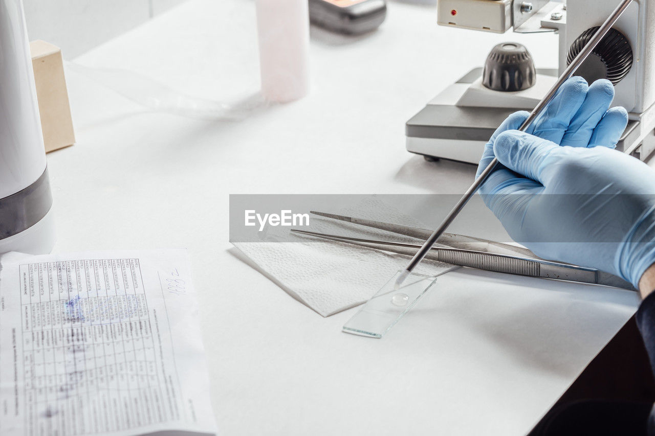 Laboratory technician engaged in setting up experiment, indicative of ongoing research, scientific 