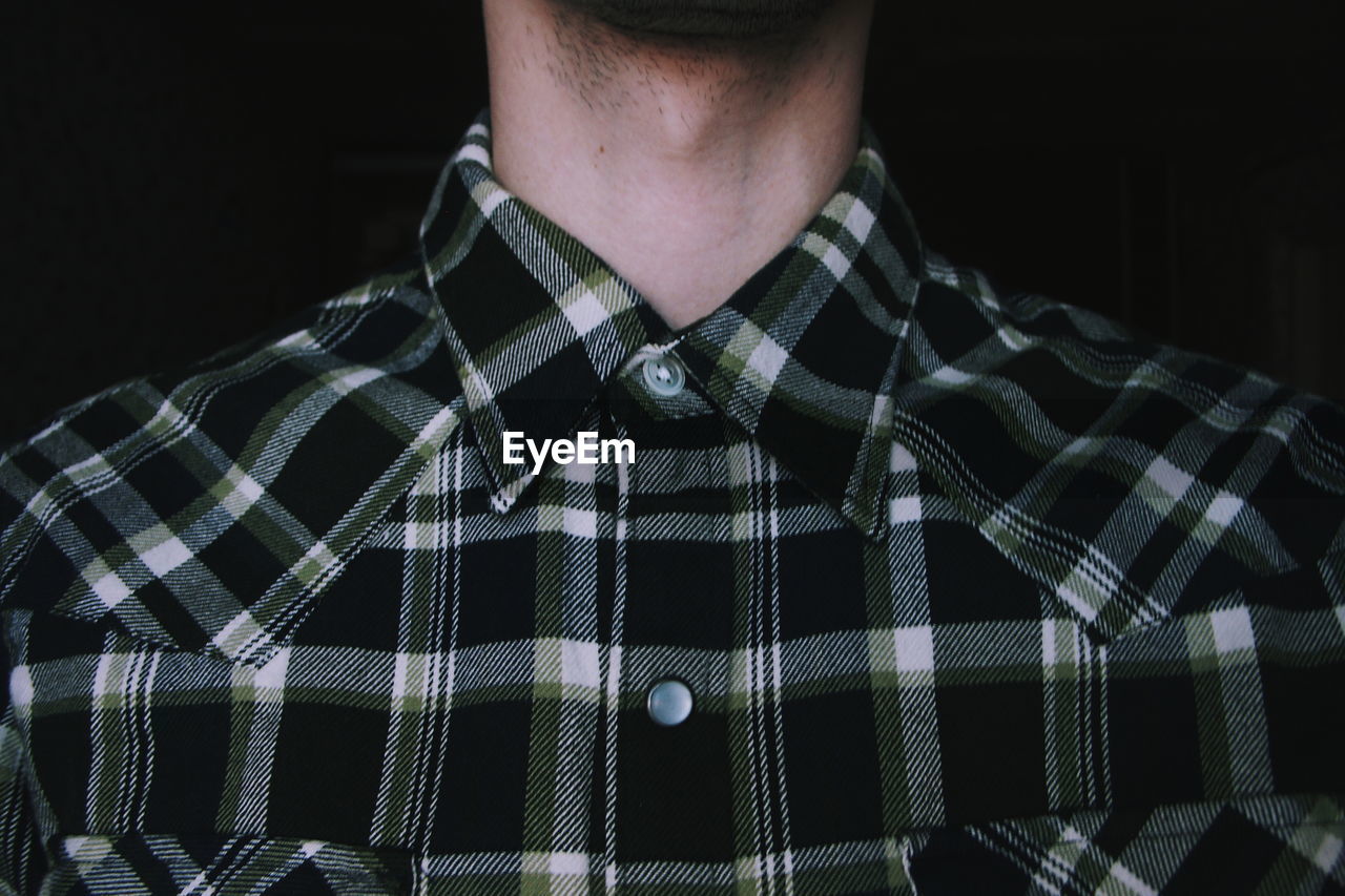Midsection of man wearing checked pattern shirt
