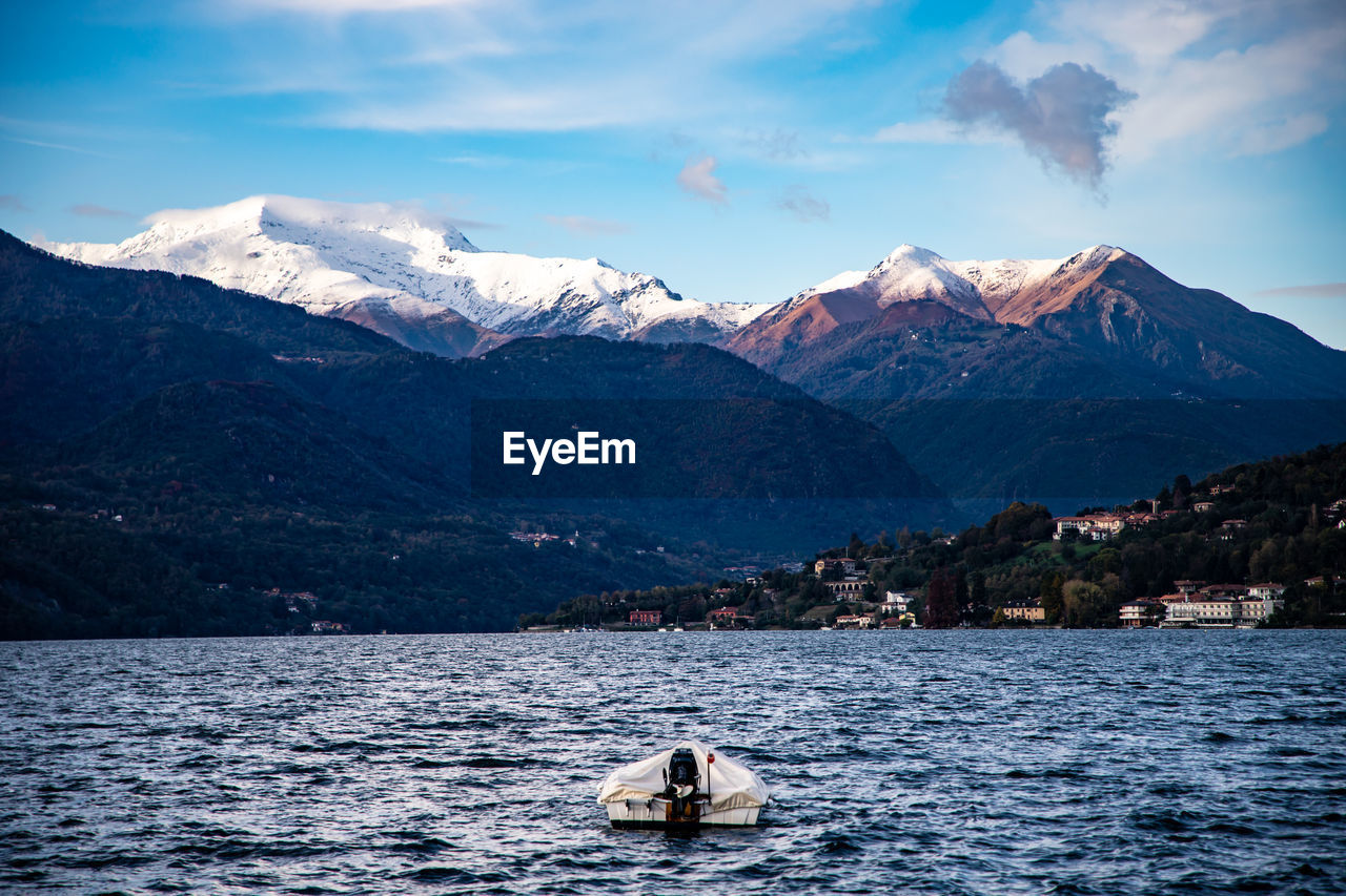 Scenic view of snowcapped mountains by sea against sky