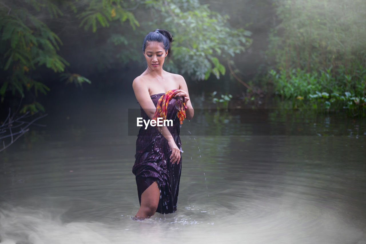 Full length of woman standing in lake