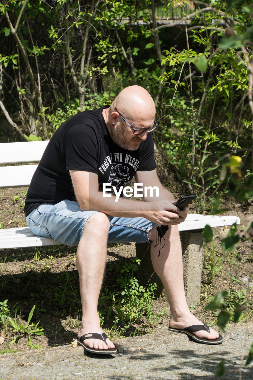 FULL LENGTH OF A MAN SITTING ON PLANT