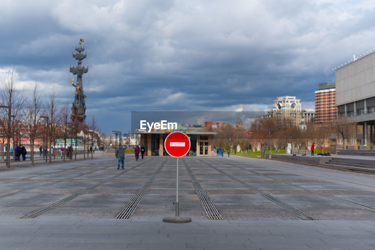 Road sign in city against sky