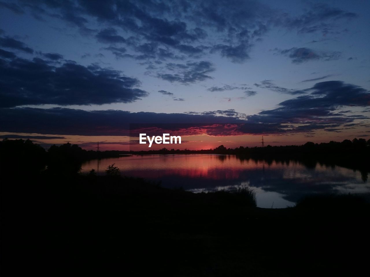 Scenic view of lake against sky at sunset