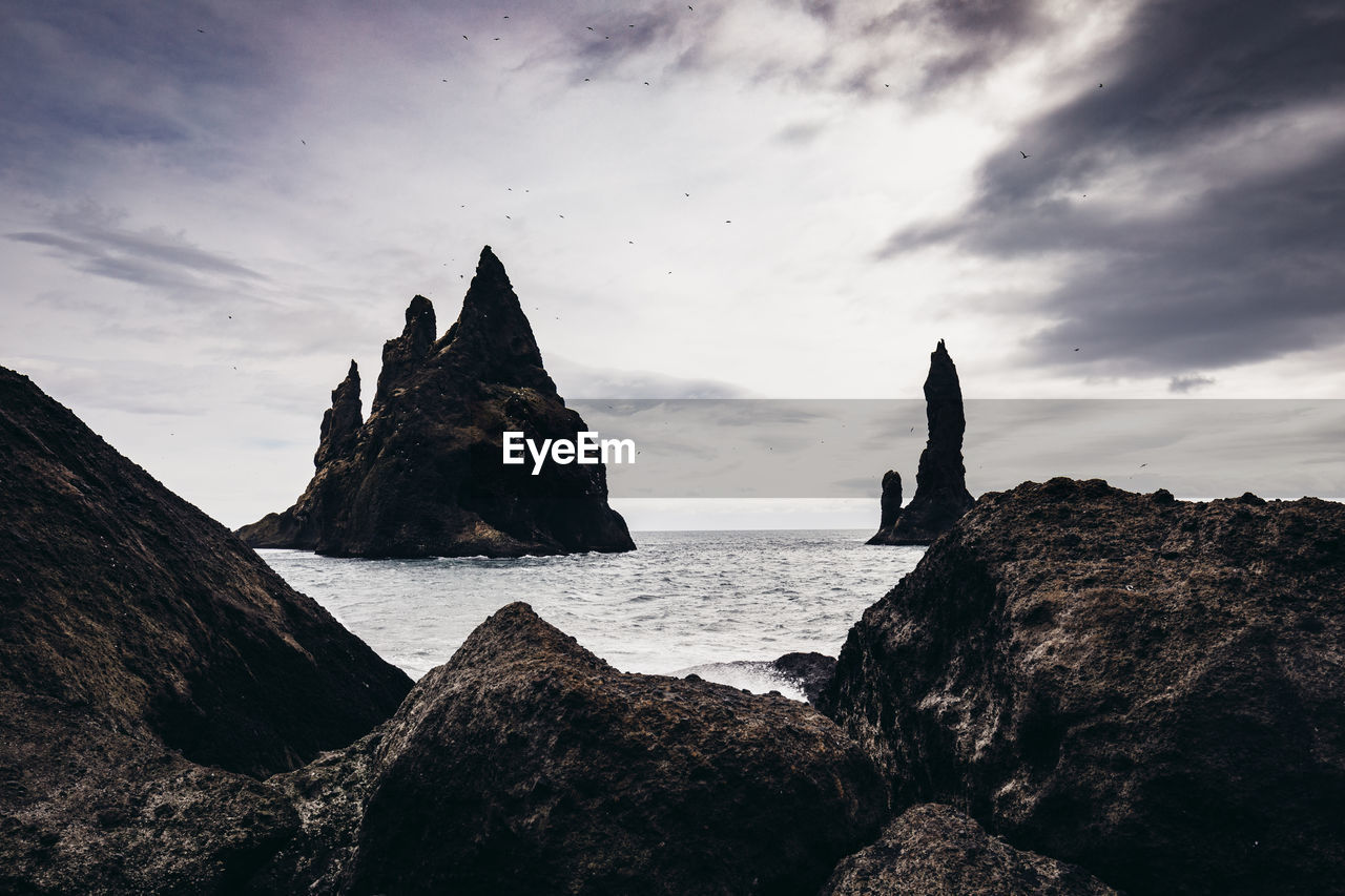 Rocks on beach against sky