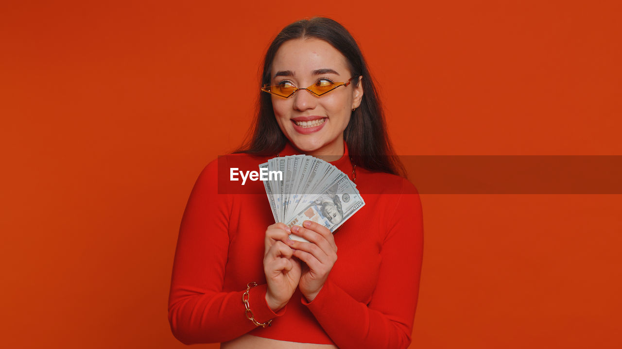 portrait of young woman against red background