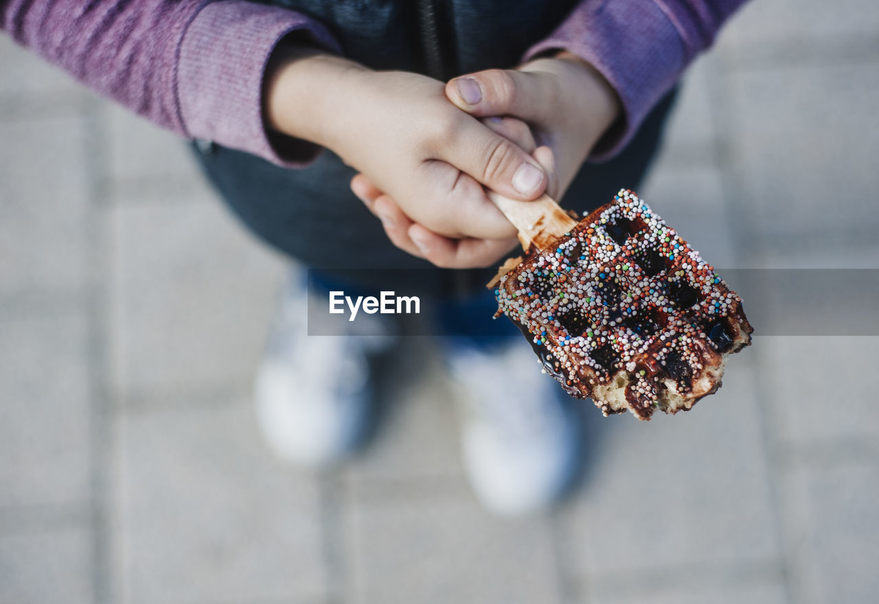 Low section of girl holding chocolate ice cream