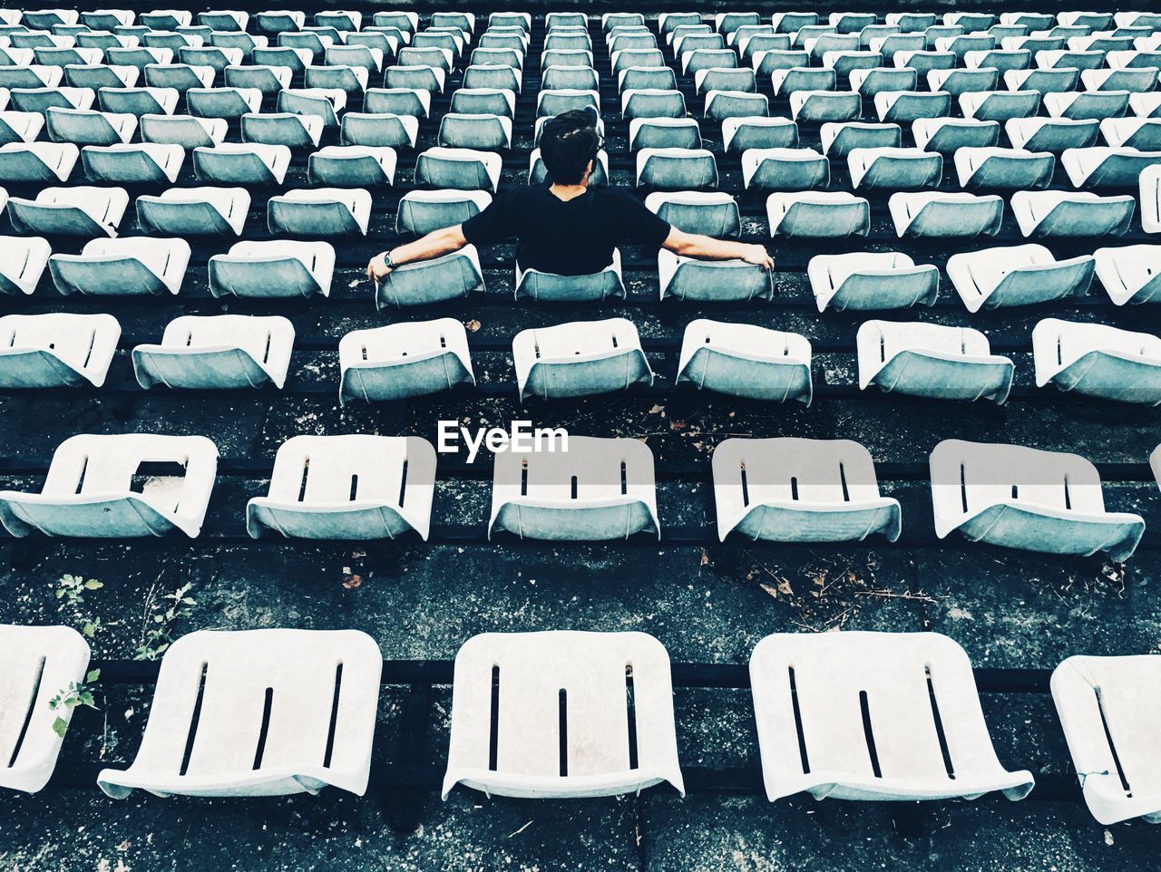 Full length of man sitting on bleacher in stadium