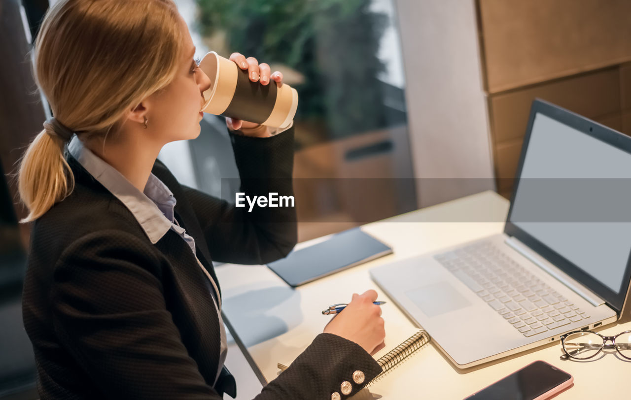 Businesswoman drinking coffee at office