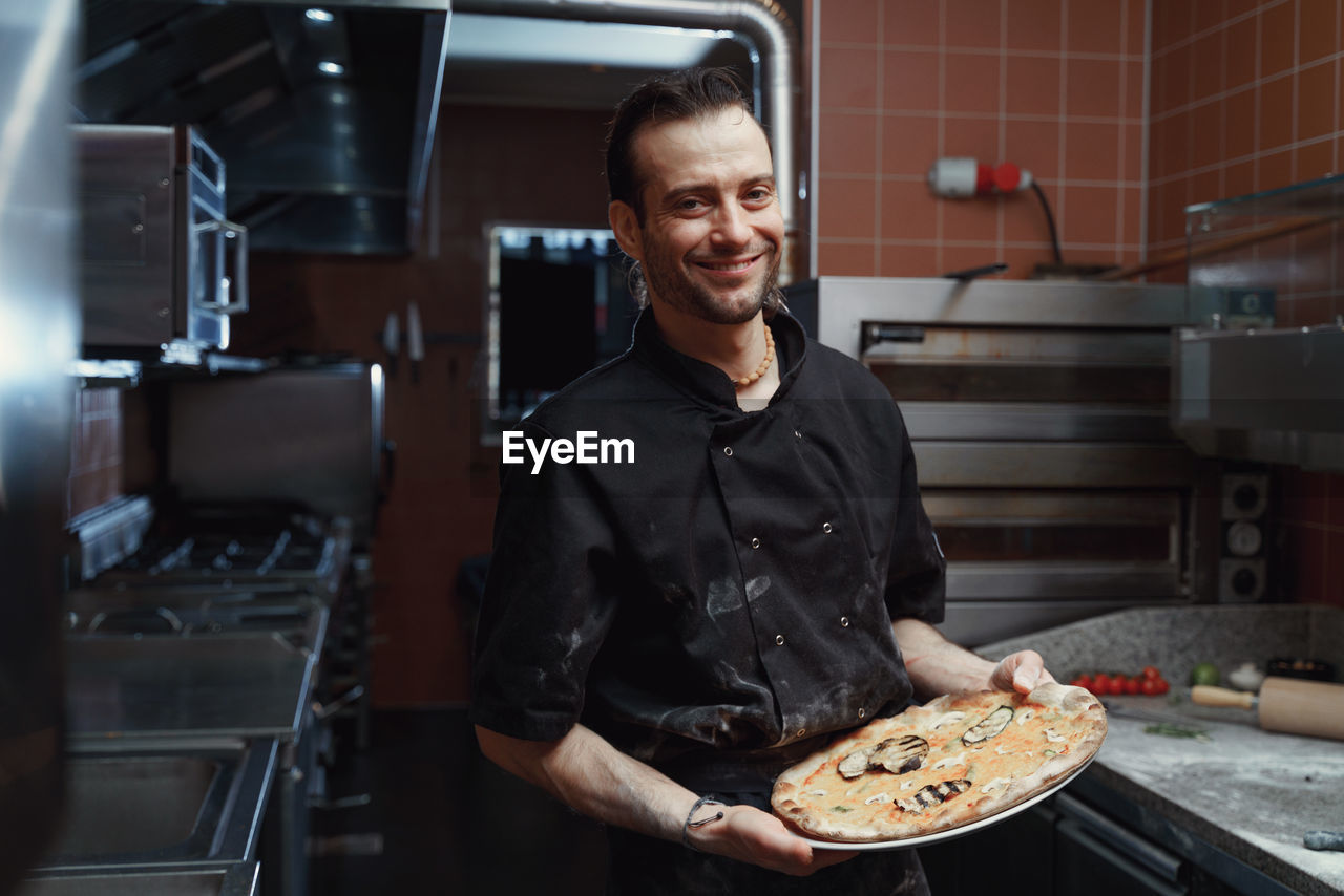 Fresh italian pizza making process. man making pizza at the kitchen