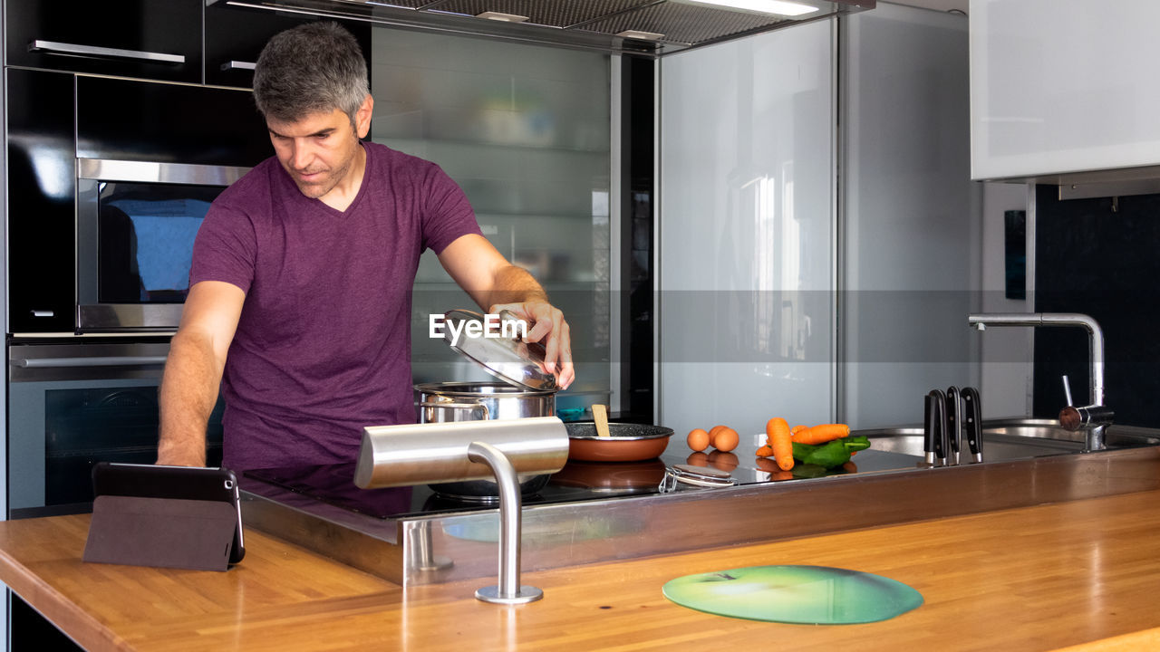 Man taking online cooking lessons through a tablet. e-learning lessons