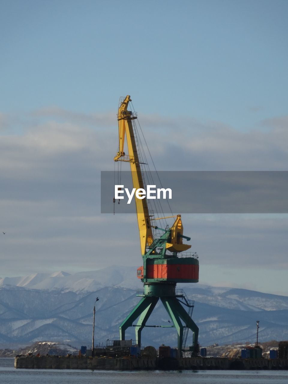 Cranes on pier against sky