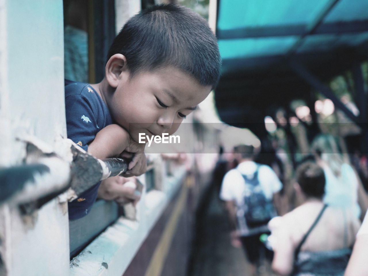 PORTRAIT OF BOY LOOKING THROUGH CAMERA WHILE SITTING ON FLOOR