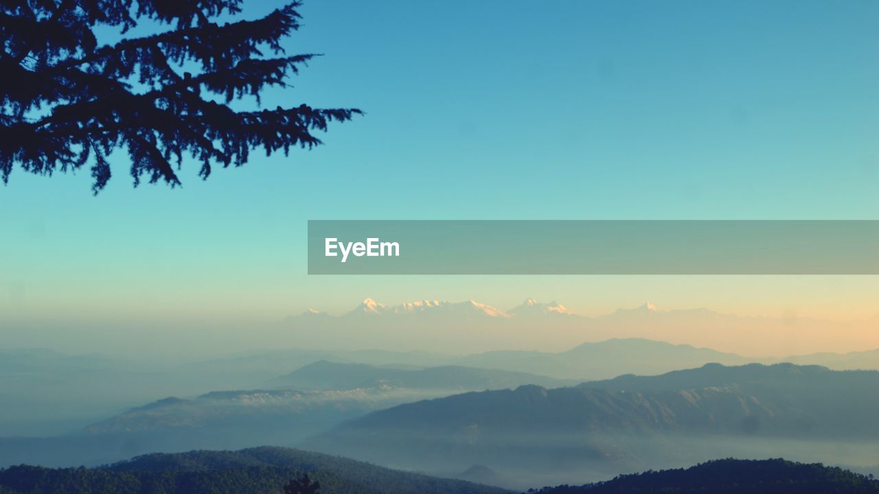 Scenic view of silhouette mountains against sky at sunset