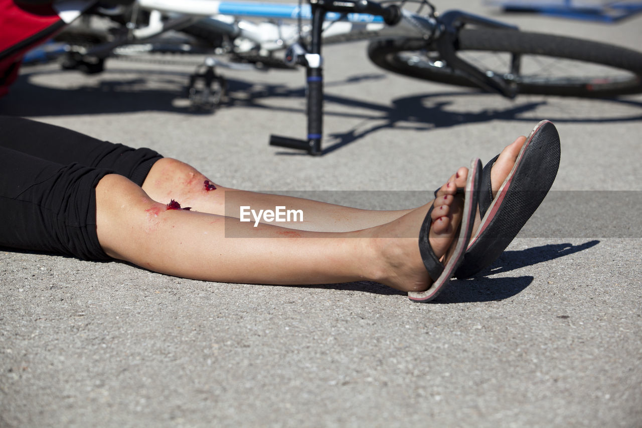 CLOSE-UP LOW SECTION OF WOMAN LYING ON FLOOR