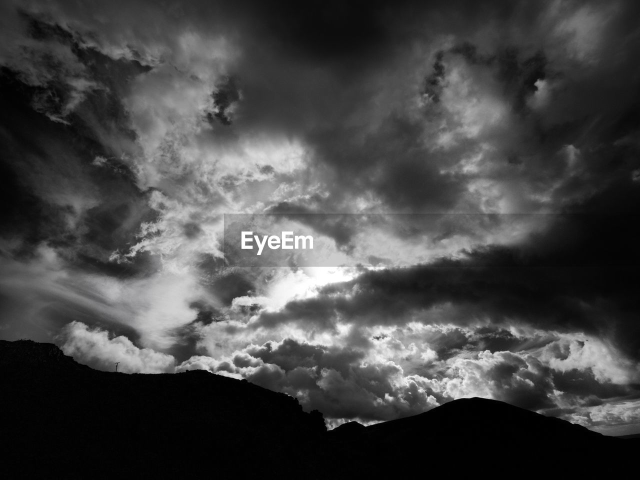 Low angle view of mountains against cloudy sky