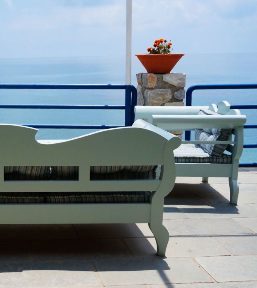 Sofa on floor by railing against sea