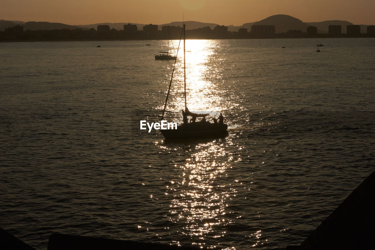 SILHOUETTE OF SAILBOAT IN SEA AGAINST SKY