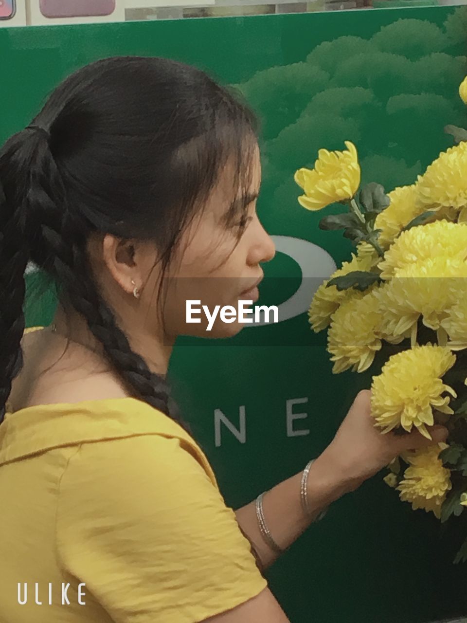 CLOSE-UP OF WOMAN BY YELLOW FLOWERING PLANTS