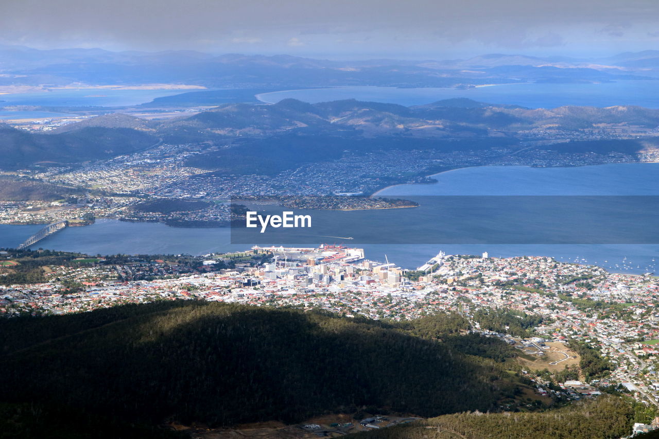 High angle view of town by sea against sky