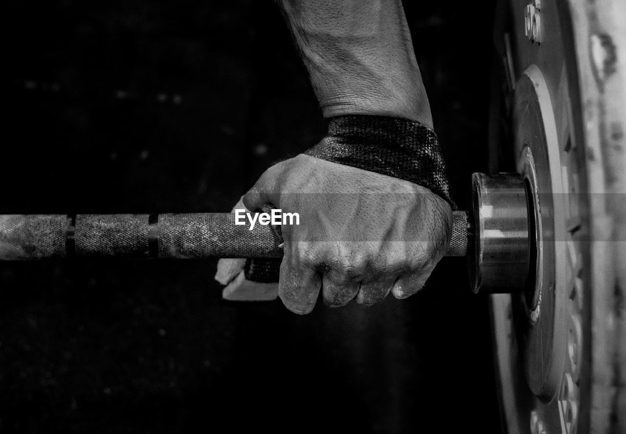 Close-up of male hands holding weights