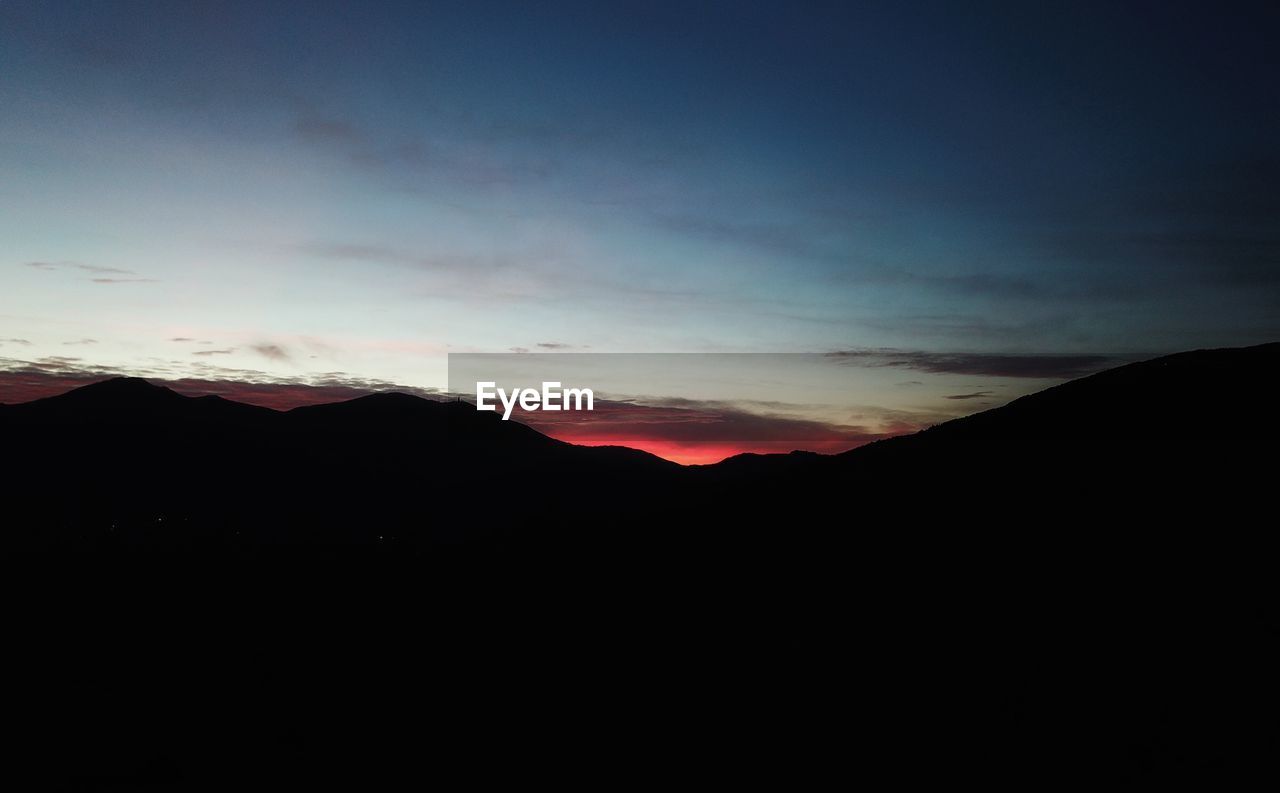 SCENIC VIEW OF SILHOUETTE MOUNTAINS AGAINST SKY DURING SUNSET