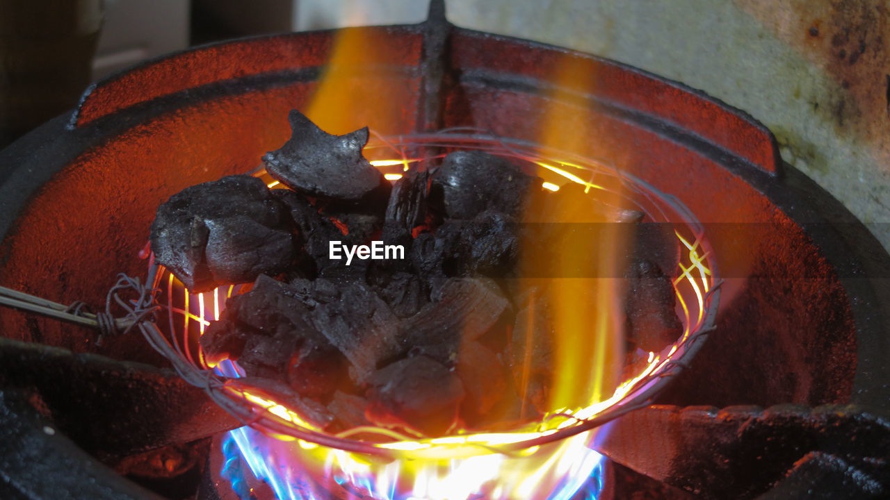 CLOSE-UP OF BURNING CANDLES ON BARBECUE