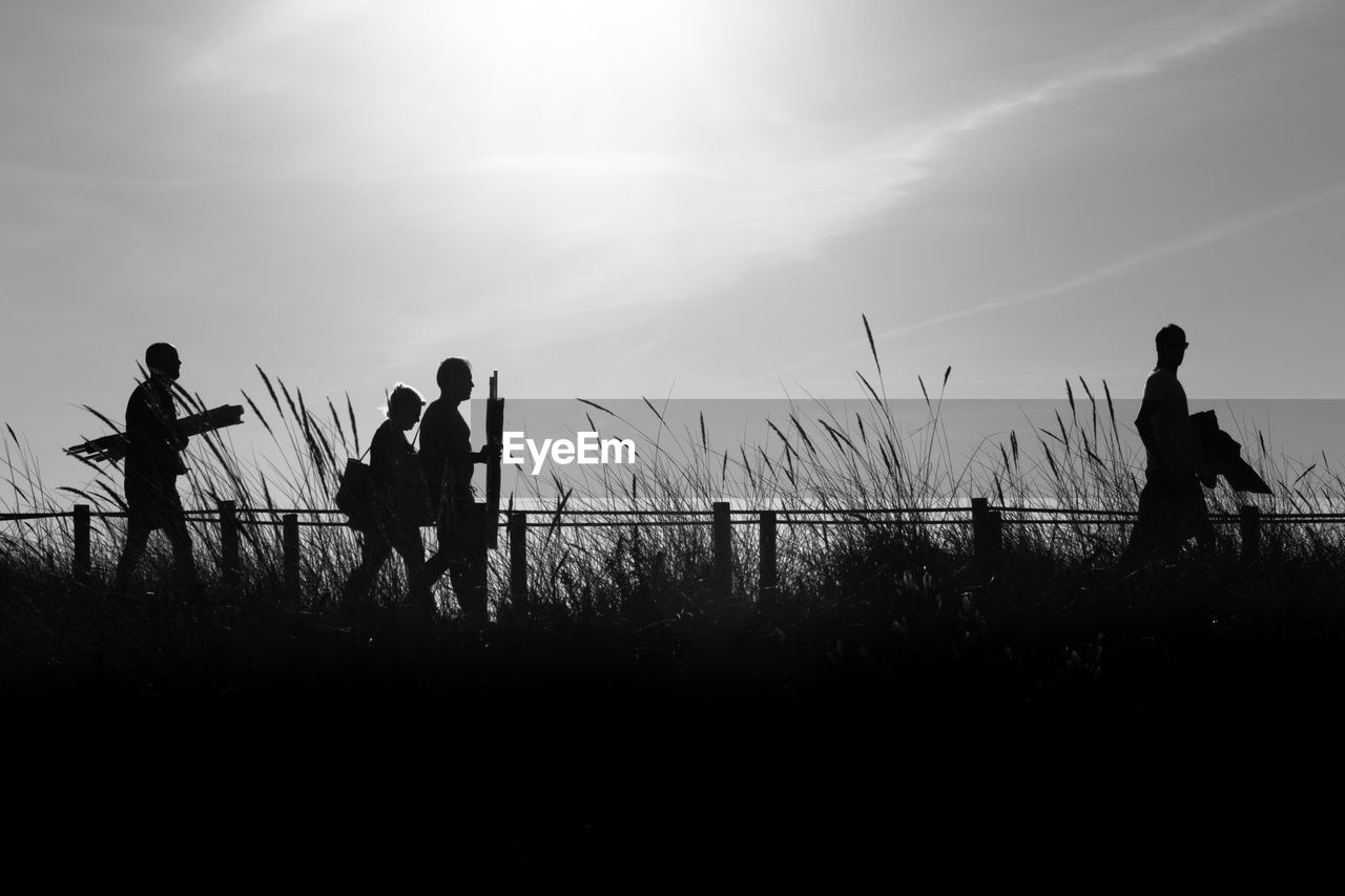 SILHOUETTE PEOPLE ON FIELD AGAINST SKY