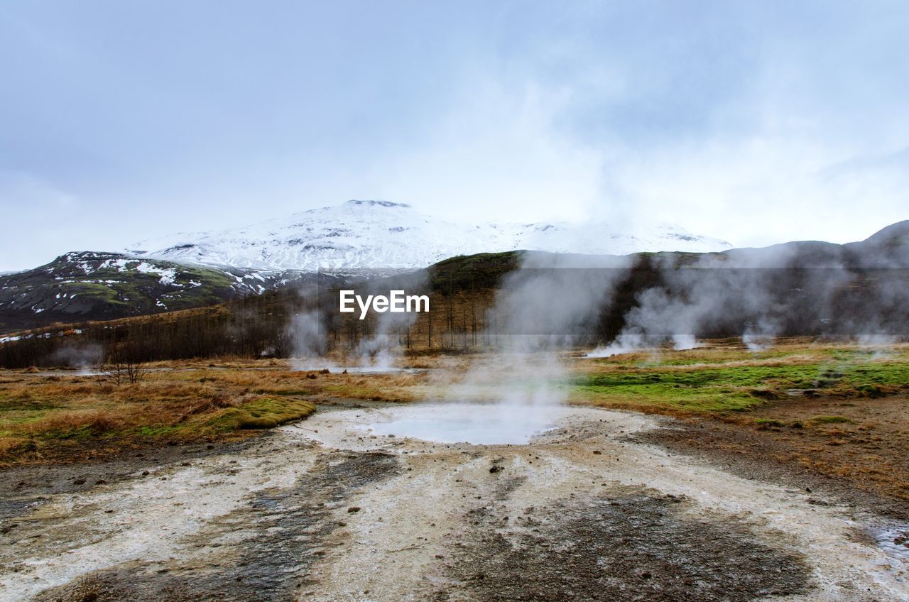 SCENIC VIEW OF WATERFALL IN MOUNTAINS