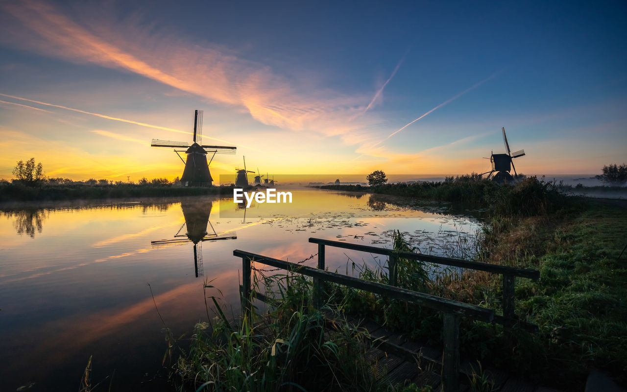 Scenic view of lake against sky during sunset, windmill, kinderdijk